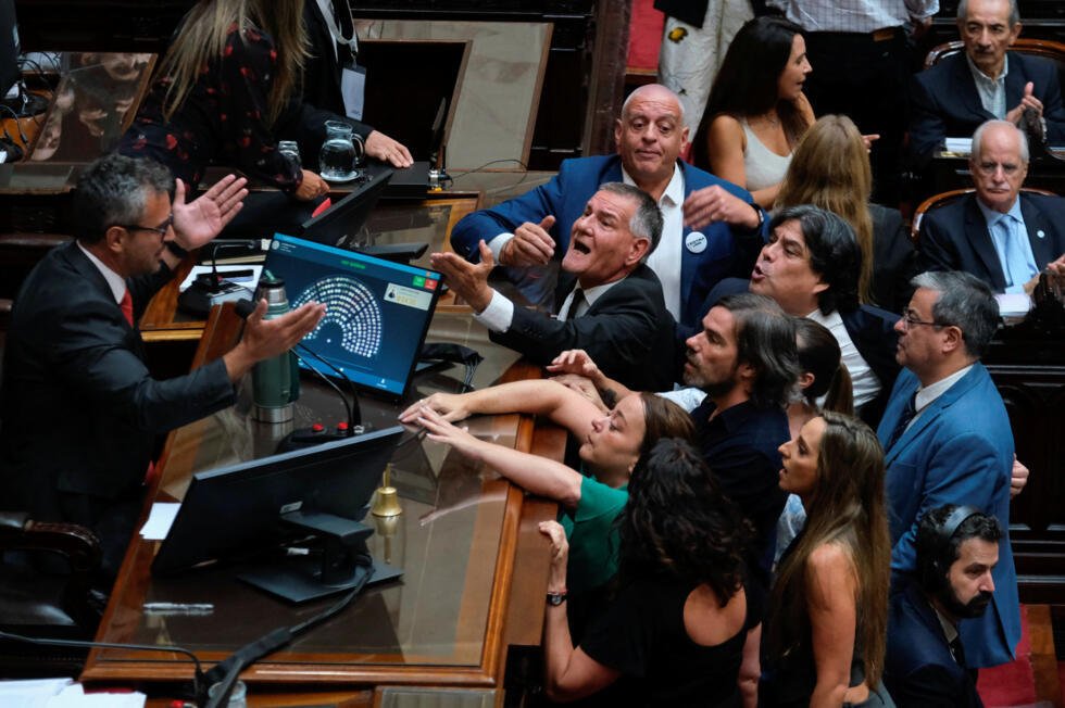 Legisladores de la oposición discuten con el presidente de la Cámara de Diputados, Martín Menem, durante un debate sobre las reformas laborales propuestas por el gobierno del presidente Javier Milei para atraer inversiones y reactivar el crecimiento, que según los sindicatos haría retroceder los derechos de los trabajadores, en el Congreso Nacional en Buenos Aires, Argentina, el 19 de febrero de 2026.