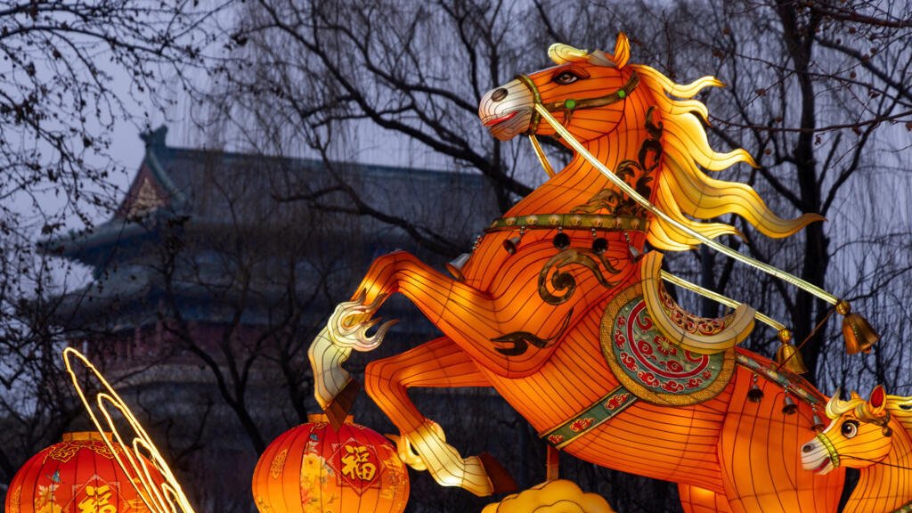 Una instalación de luz que representa un Caballo de Fuego aparece junto a la Torre de la Puerta de Zhengyang antes del Año Nuevo Lunar, en Beijing, China, el 13 de febrero de 2026. 