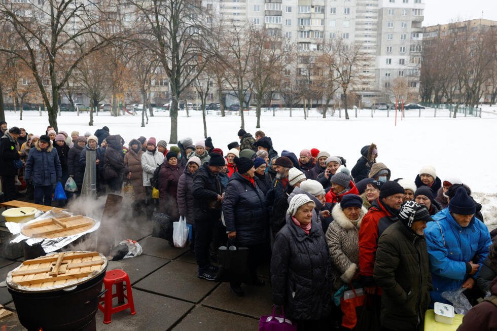 Los residentes hacen fila para recibir comidas gratuitas preparadas por kazajos que viven en Ucrania, en un barrio donde muchos edificios de apartamentos se quedaron sin electricidad, calefacción ni suministro de agua tras los recientes ataques con misiles y drones rusos contra infraestructura civil crítica, en medio del ataque de Rusia a Ucrania, en Kiev, Ucrania, el 13 de febrero de 2026.