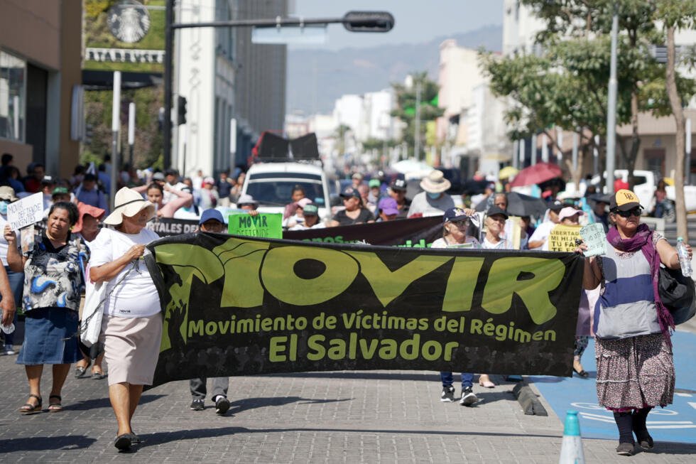 Activistas salvadoreños marchan durante una protesta contra los juicios masivos bajo el régimen de excepción, que permite detenciones sin orden judicial, en San Salvador, el 15 de febrero de 2026