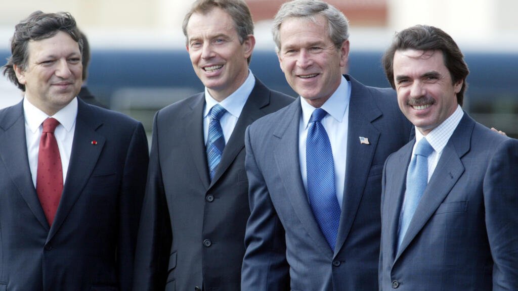 El presidente George Bush, en el centro, el primer ministro británico Tony Blair, a la izquierda, y el presidente del Gobierno español José María Aznar, a la derecha, tras llegar a la base aérea conjunta portuguesa-estadounidense de Lajes, en la isla de Terceira, en el archipiélago de las Azores, el domingo 16 de marzo de 2003, para asistir a una cumbre en la que se debatirá la crisis con Irak.