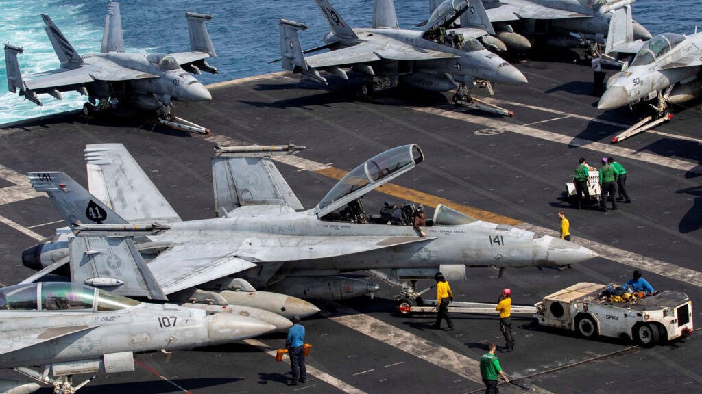 En esta foto de archivo marineros de la Marina de EE. UU. trasladan un caza F/A-18F Super Hornet en la cubierta de vuelo del portaaviones de clase Nimitz USS Abraham Lincoln, en apoyo de la operación Epic Fury contra Irán.