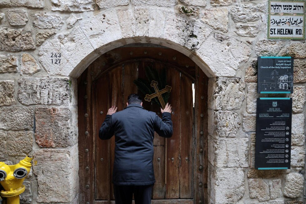 Issa Kassissieh, un cristiano palestino se encuentra frente a las puertas de la Iglesia del Santo Sepulcro tras encontrarlas cerradas, tras la cancelación de la tradicional procesión del Domingo de Ramos desde el Monte de los Olivos, en medio de las restricciones a las concentraciones de grandes grupos y del conflicto entre Estados Unidos, Israel e Irán, en la Ciudad Vieja de Jerusalén, el 29 de marzo de 2026.