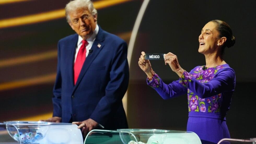 El presidente de Estados Unidos, Donald Trump, mira a la presidenta mexicana Claudia Sheinbaum, mientras esta levanta el nombre de la selección mexicana durante el sorteo de la Copa Mundial de Fútbol 2026 en el Kennedy Center de Washington, el viernes 5 de diciembre de 2025.