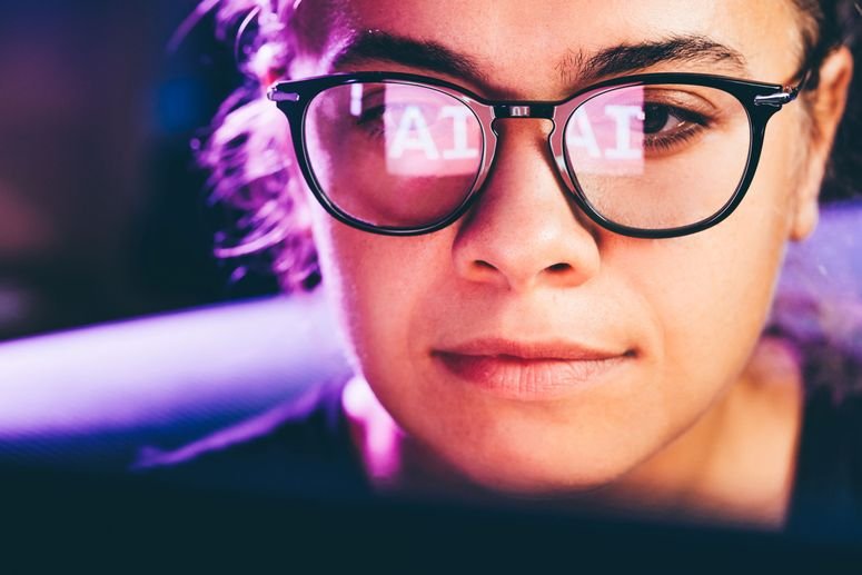 Imagen conceptual de una mujer consultando contenido creado por IA en una computadora portátil.