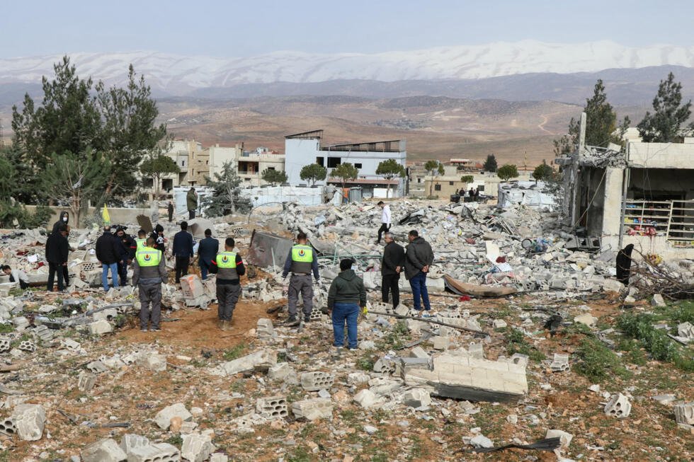 Residentes y personal de emergencia permanecen entre los escombros en el lugar donde se produjo un ataque aéreo israelí durante la noche en la aldea de Younine, en el valle de la Bekaa, en Líbano, el 12 de marzo de 2026.