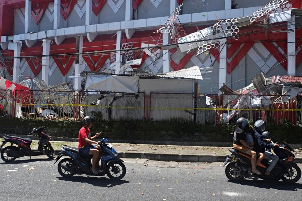 Motociclistas pasan junto a un edificio dañado durante un terremoto en Manado, en la provincia de Célebes Septentrional, Indonesia, el 2 de abril de 2026.