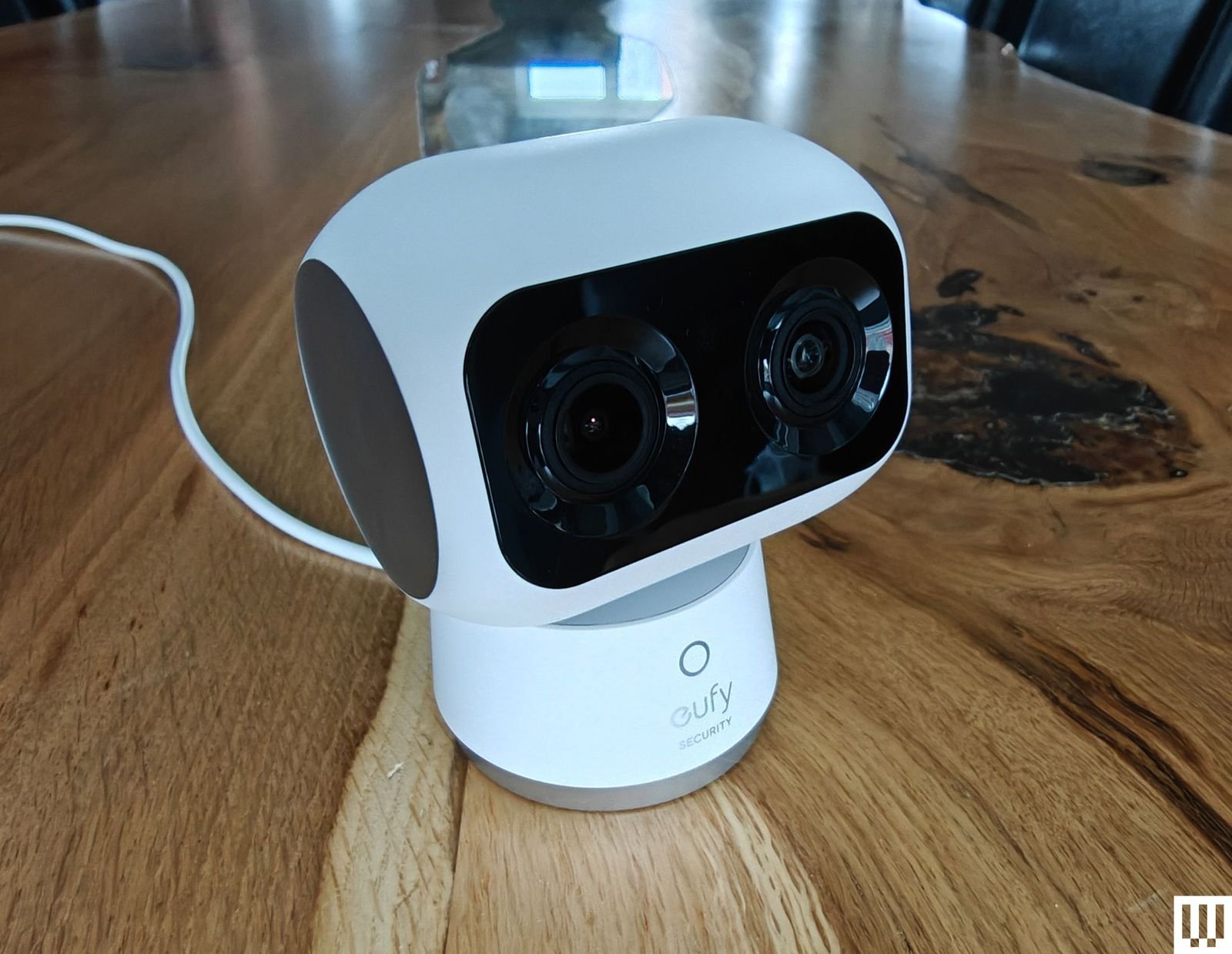 Cmara de seguridad interior con forma de robot colocada sobre una superficie de madera.