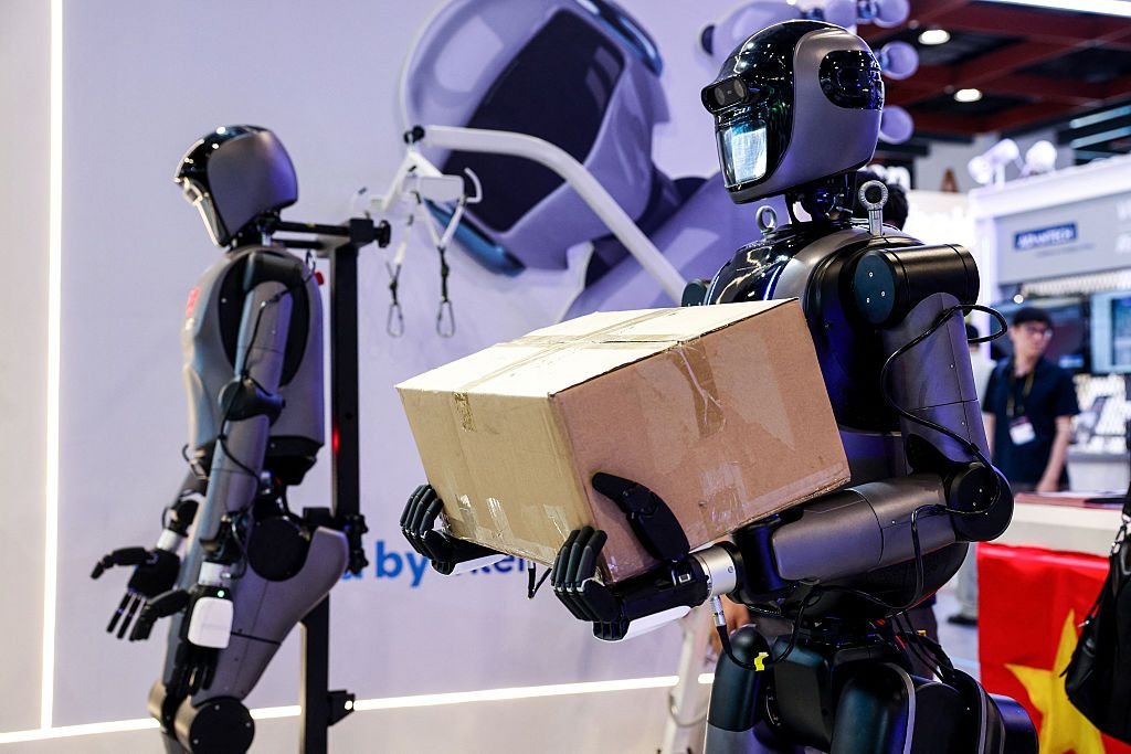Un robot humanoide transporta una caja de cinco kilogramos durante una demostración en el stand de Intel en la feria...