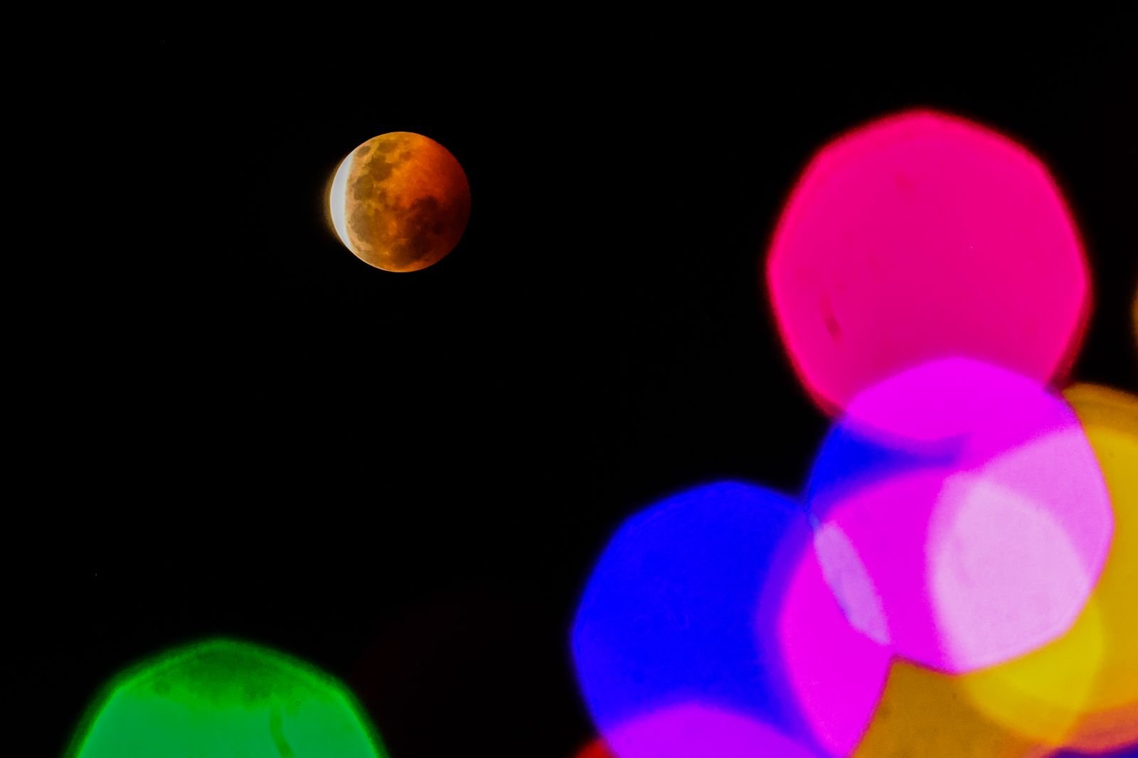 Una imagen del eclipse lunar con los colores reflejados de la ciudad de Valparaiso Chile.