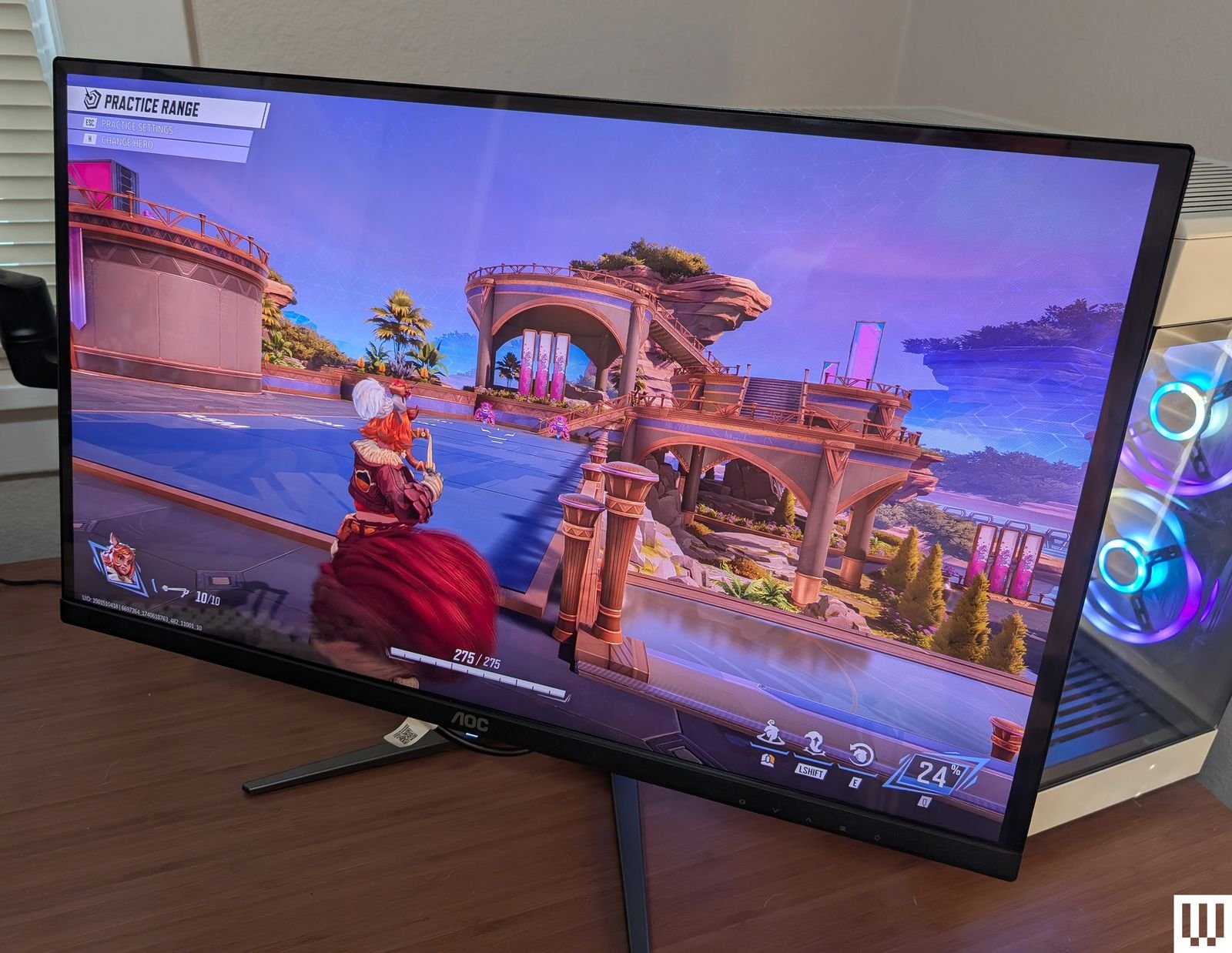 Vista frontal del monitor para videojuegos AOC Q27G4ZD QDOLED colocado sobre un escritorio de madera con la pantalla...
