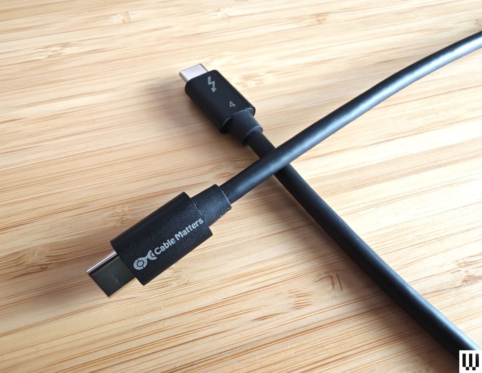 Vista desde arriba del cable Cable Matters USBC a USBC Thunderbolt 4 con dos cables negros que se cruzan sobre una...