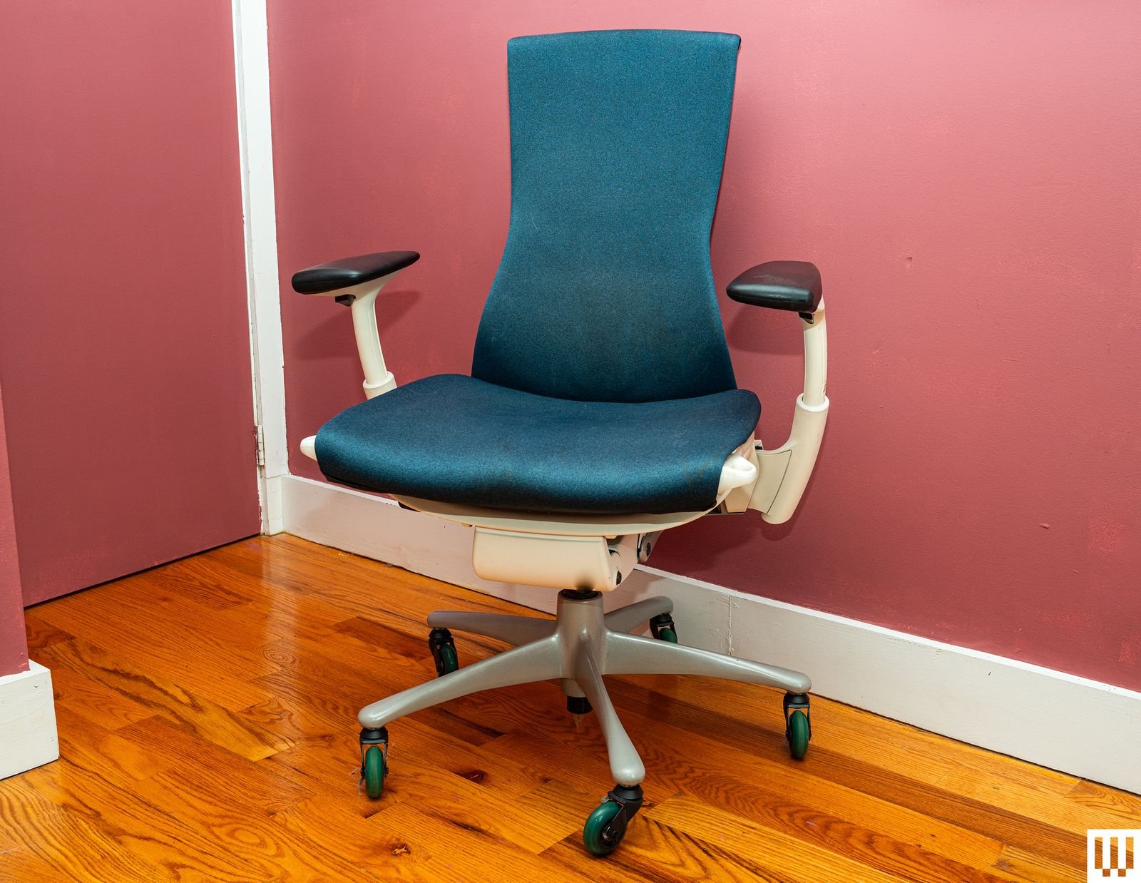 Vista frontal de una silla de oficina azul y blanca con respaldo en forma de reloj de arena y asiento acolchado en una...