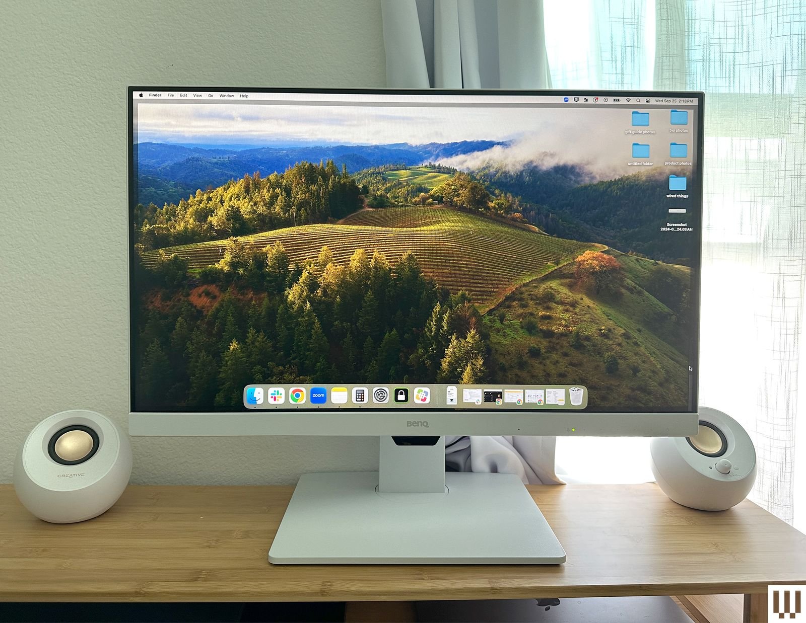 Monitor BenQ una pantalla de computadora blanca y delgada con una base cuadrada colocada sobre una mesa de madera con un...
